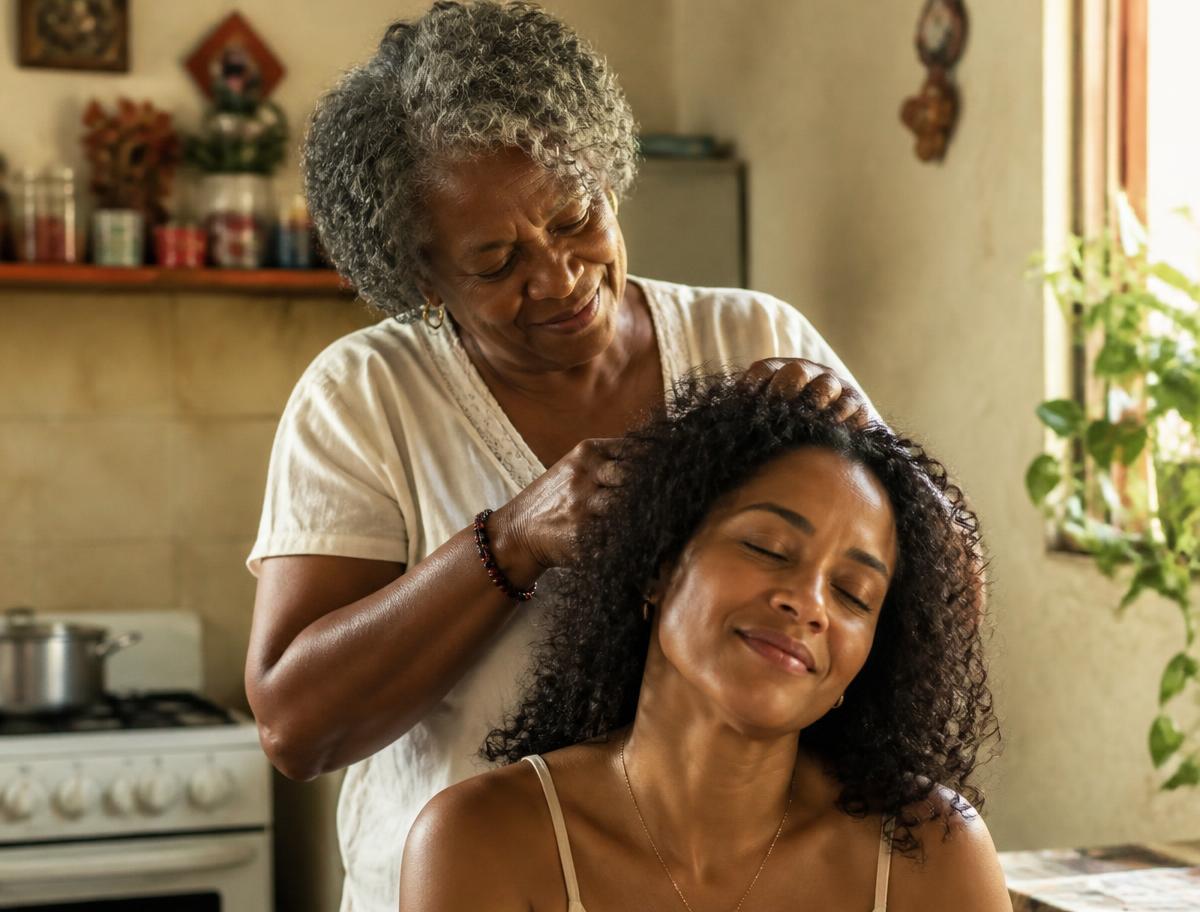 Madre cuidando el cabello rizado de su hija en casa